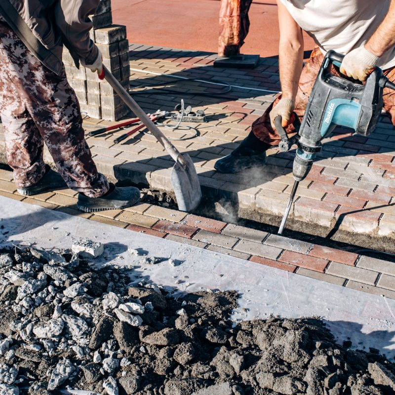 Workers laid paving slabs. Two workers lay paving slabs. Workers laid paving slabs. Two workers lay paving slabs.